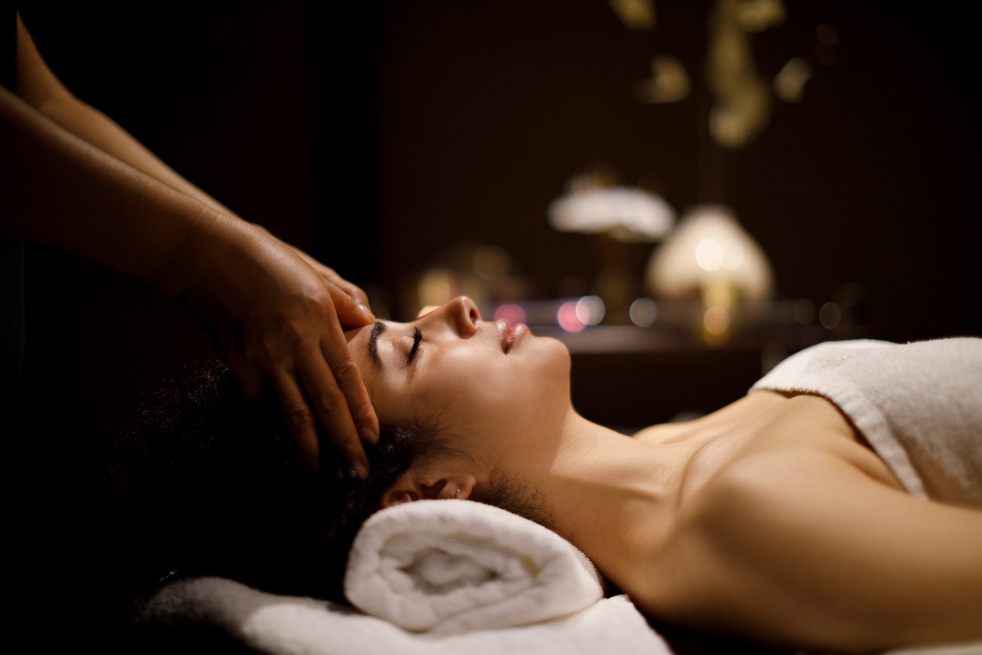 Woman enjoying head massage in spa center